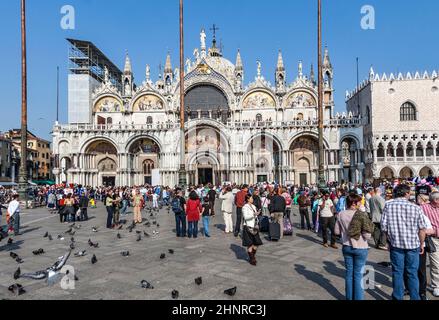 group of young people pose in front of san Marco church basilica at San Marco square in Venice, Italy. Stock Photo