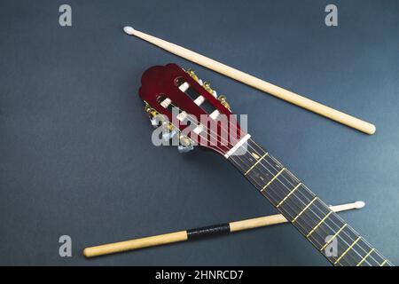 Drumsticks and guitar headstock close up. acoustic musical instrument ...