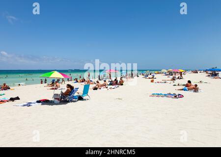 People enjoy swimming in South Beach  in Miami Beach, USA. In 1870, Henry and Charles Lum purchased the area and his daughter Taylor named it South Beach. Stock Photo