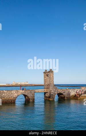 young people enjoy swimming at castle Castillo de San Gabriel in Arrecife Stock Photo