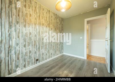 Empty room with wall paper in green tones with a glass lamp and wooden floors Stock Photo