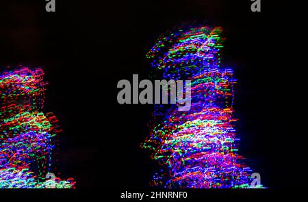 colorful abstract design of christmas tree lights with creative motion created by intentional camera movement and slow shutter speed outdoor xmas tree Stock Photo