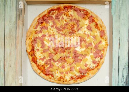 Hawaiian pizza contains a base of melted cheese and tomato with ham and pineapple. Some include bacon, shrimp, cherries, red peppers, mushrooms, onion Stock Photo