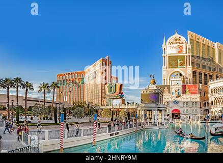 famous hotel The Venetian at the strip with people in gondolas and the casino treasure island in background Stock Photo