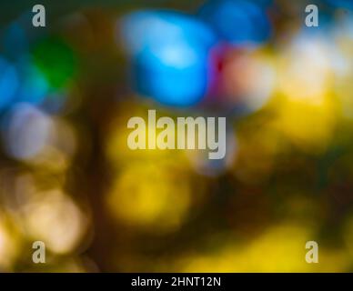 bokeh special effects soft focus of Christmas colored lights in outdoor tree winter green red yellow and white bokeh circles colorful balls vertical Stock Photo