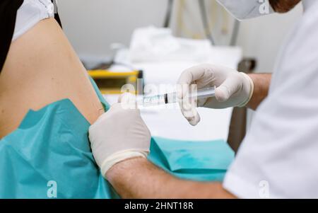 Orthopedic doctor injecting cortisone in slipped disc during infiltration therapy Stock Photo