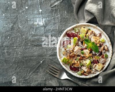 Waldorf salad with copy space. American fruit and nut salad with apples, celery, grapes, chicken meat, dressed mayonnaise. Craft plate with ready-to-e Stock Photo