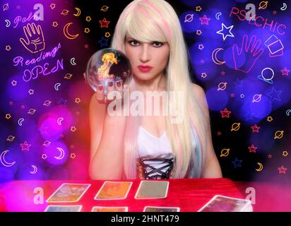 Psychic with Blond hair and Crystal Ball. Neon Lights in background Stock Photo