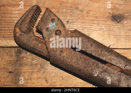 Pipe wrench on wood background. adjustable gas wrench. instrument for repair. working tool Stock Photo