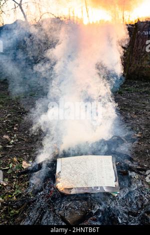 vintage fashion magazine burning in fire on ash Stock Photo