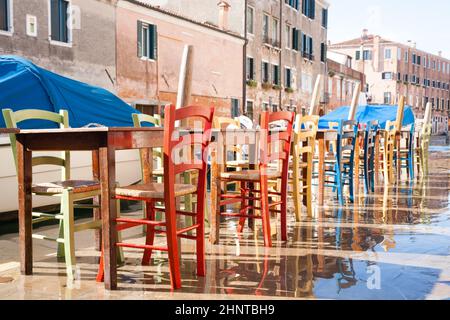 Colorful chairs in a row along Venetian canal Stock Photo