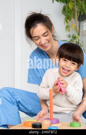 Disabled child is playing, learning and exercising in rehabilitation therapy hospital, Lifestyle of a child with disability. Happy disability kid concept. Stock Photo