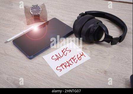 Handwriting text Sales Strategy. Conceptual photo Plan for reaching and selling to your target market Marketing Blank Notebook Page With A Calculator And Geometric Stationery Over Table. Stock Photo