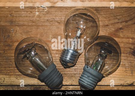 Light bulb on a wooden background. old lamp lies on the table. Stock Photo