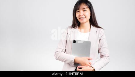 Portrait of Asian beautiful young woman smiling holding tablet computer, Happy lifestyle female teen hugging digital tablet pc, studio shot isolated o Stock Photo