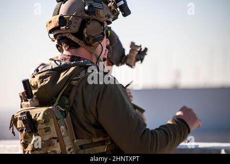 A Special Tactics (ST) joint terminal attack controller, front, and an ST combat controller with the 125th Special Tactics Squadron (STS), Oregon Air National Guard, discuss targeting information for simulated opposition forces during a training exercise in Oklahoma City, Jan. 12, 2022. The 125th STS trained with the help of members with the 137th Special Operations Wing (SOW) acting as opposition forces during scenarios that required the controllers to track their movement while coordinating a stack of aircraft that was composed of a 137th SOW MC-12W and an AC-130J Ghostrider assigned to Cann Stock Photo