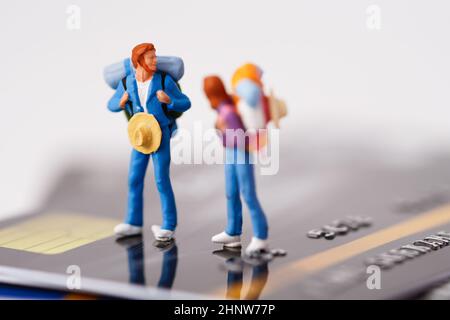 Traveler with backpack standing on stack of credit card, management business finance transport travel concept. Stock Photo