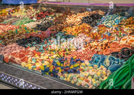 Assortment of gummy candies and sweets in the stall. Assorted colorful different shape jelly candies on the market. Stock Photo