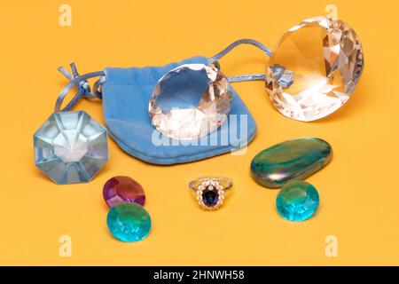 Blue sapphire diamond ring expensive jewelry and large gemstones on the back on yellow background Stock Photo