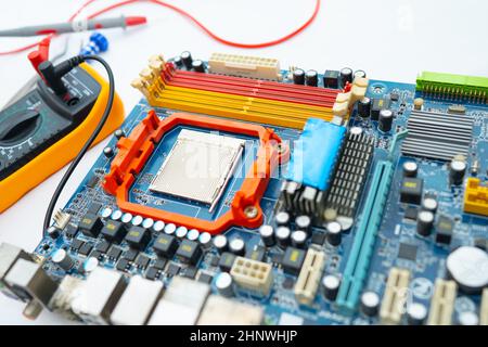 Multimeter with main board, maintenance, repairing and checking computer hardware concept. Stock Photo