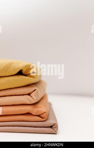 Stacks colorful cotton fabric, clothes. Copyspace Stock Photo