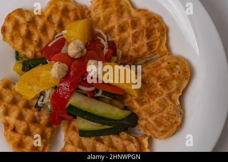 vegan waffles with fruit, vegetables and almond flour batter on a white background.