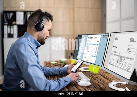 Looking At Invoice And Spreadsheet On Computer At Work Stock Photo