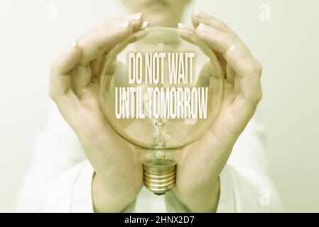 Conceptual caption Do Not Wait Until Tomorrow, Word Written on needed to do it right away Urgent Better do now Lady in outfit holding lamp with two ha Stock Photo