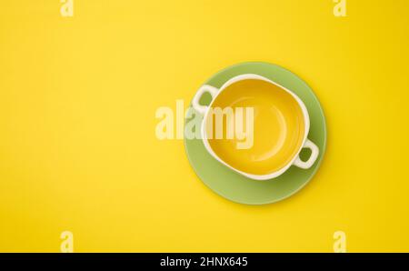 empty yellow soup plate on a yellow bacground, top view Stock Photo