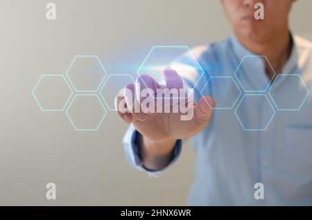 man points to a futuristic interface. On a virtual screen, a businessman presses a button. concept for a business There is space for text. Stock Photo