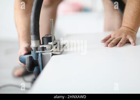 Male hands working with an electric plane close-up Stock Photo