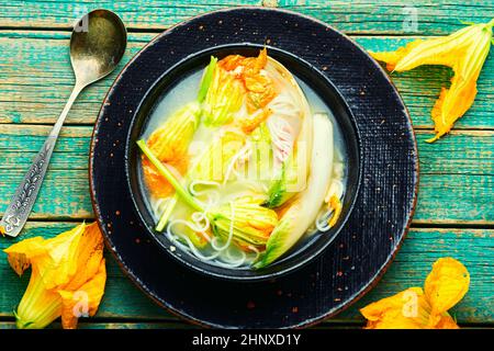 Soup with rice noodles and dumplings in pumpkin flowers.Flat lay Stock Photo