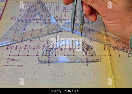 Electrical engineer workplace - electrotechnical project, rulers, and divider compass. Construction and electrotechnology concept. Engineering tools. Stock Photo