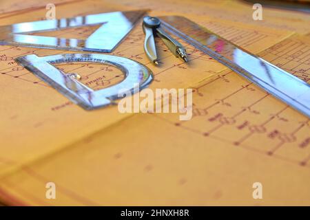Electrical engineer workplace - electrotechnical project, rulers, and divider compass. Construction and electrotechnology concept. Engineering tools. Stock Photo