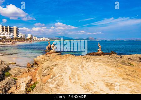 Stone sculptures in the rough natural coastal and Playa del Muro beach landscape panorama with turquoise water waves and mountains in Can Picafort on Stock Photo