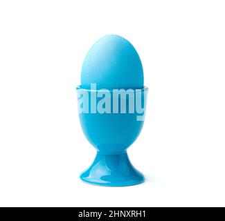 A blue Easter egg on a stand is isolated on a white background. Side view, close-up. The concept of Easter. Stock Photo