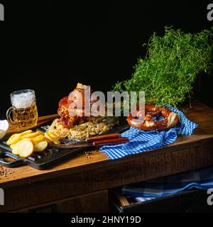 rustic pork knuckle with sauerkraut, sweet mustard and fried potatoes Stock Photo