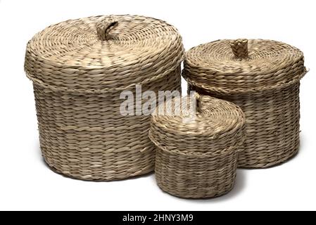 Close up of group three a small middle and big basket woven from straw or willow with decorative lid on it on white background Stock Photo