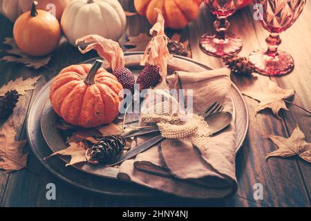 Place setting for Thanksgiving with pumpkins and autumn leaves in vintage style Stock Photo