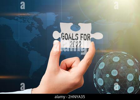 Text showing inspiration Goals For 2022, Conceptual photo object of persons ambition or effort aim or desired result Hand Holding Jigsaw Puzzle Piece Stock Photo