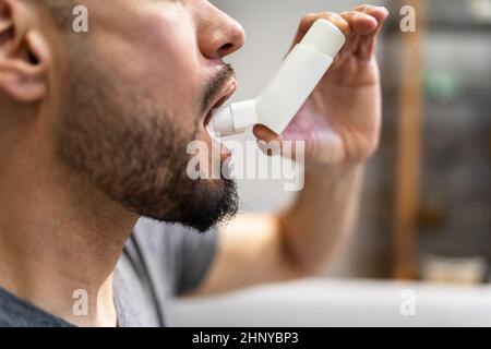 Man With Asthma Using An Asthma Inhaler For Preventing Attacks Stock Photo