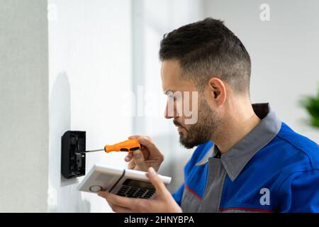 Technician Installing Security Access Alarm System Control Stock Photo