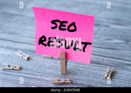 Hand writing sign Seo Result, Word Written on the list created by search engines in response to a query Piece Of Blank Square Note Surrounded By Laund Stock Photo