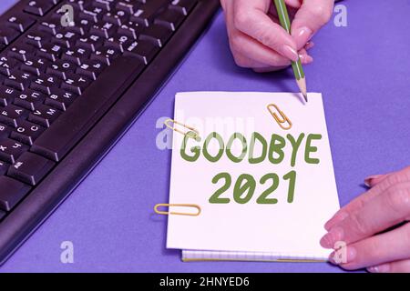 Handwriting text Goodbye 2021, Word for express good wishes when parting or at the end of last year Hands pointing pressing computer keyboard keys typ Stock Photo