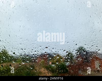 Rain drops running down a car window in a close up view Stock Photo