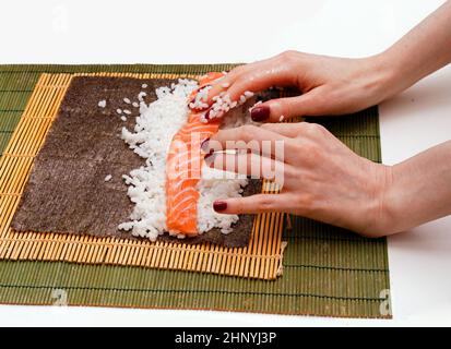 Woman using bamboo rolling mat for home made sushi Stock Photo - Alamy