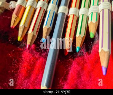 Selective focus close up at color pens lying on a red felt surface Stock Photo