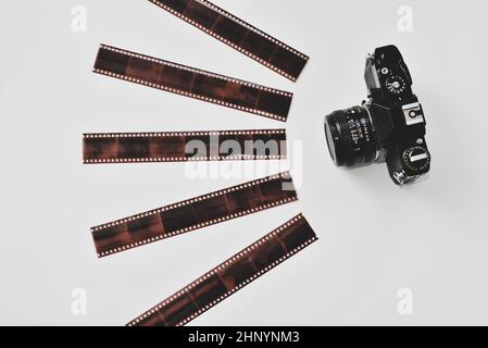 Top view of vintage analog film camera and 35mm film negatives in protective sleeves. Stock Photo