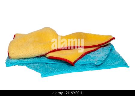 Household cleanliness and hygiene. Close-up of a blue and a yellow cleaning cloth isolated on a white background. Microfiber cleaning cloth. Macro. Stock Photo