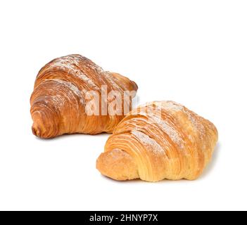two baked croissants on a white isolated background, dessert for breakfast sprinkled with powdered sugar Stock Photo